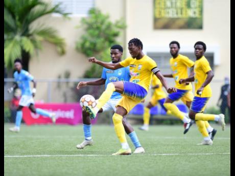 
Molynes United Captain and goalscorer Nicholas Nelson passes the ball ahead of Ramone Howell  of Waterhouse FC (left) in action from the Jamaica Premier League at the UWI-JFF Captain Horace Burrell Centre of Excellence in St Andrew yesterday. 