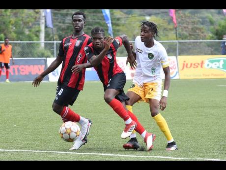 In Premier League action on Monday, February 14 2022 Arnett FC vs Vere United FC.  Arnett Gardens’ Shande James (centre) gets away from Vere United’s Tyreece Harrison (right). Looking on is James’ teammate Marlon Allen.