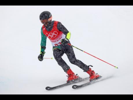 Benjamin Alexander, of Jamaica approaches a gate during the first run of the men’s giant slalom at the 2022 Winter Olympics on Sunday.