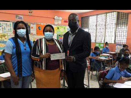 Shane Munroe, CEO, MBJ Airports Limited, hands over a cheque to Collette Barnes, principal of Flankers Primary and Junior High School. Looking on is Janet Wray Lawrence, membership director. 