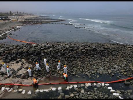 Workers continue in a clean-up campaign after an oil spill, on Pocitos Beach in Ancon, Peru on Tuesday, February 15, 2022. One month later, workers continue the clean-up beaches after contamination by a Repsol oil spill.