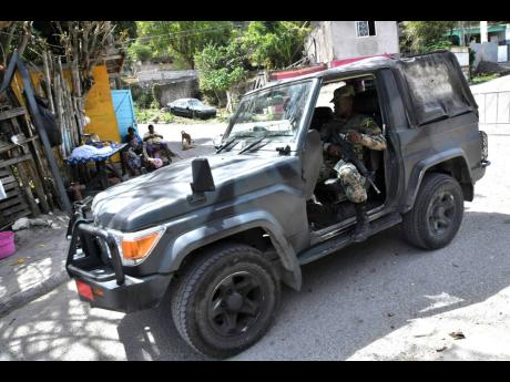Credit: Rudolph Brown/Photographer Jamaica Defence Force personnel on patrol in Goldsmith Villa in August Town, St Andrew, yesterday.