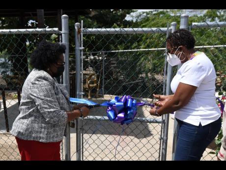 Credit: Kenyon Hemans/Photographer Mona Sue-Ho (left), senior manager of social development at the Jamaica Social Investment Fund, and Dr Angela Brown Burke, member of parliament for St Andrew South Western, cut a ribbon to mark the official opening of green space constructed at the Greenwi