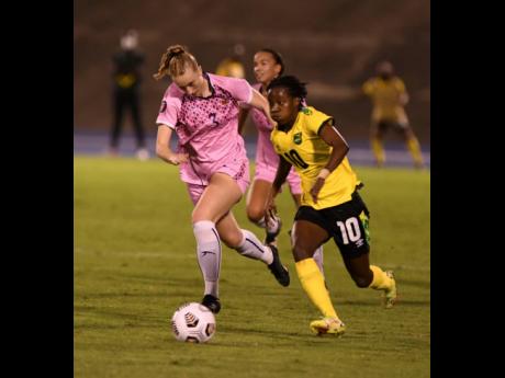 Credit: Ricardo Makyn Reggae Girlz attacker Jodi Brown, drives past a Bermudan defender during their Concacaf World Cup qualifier at the National Stadium on Sunday.