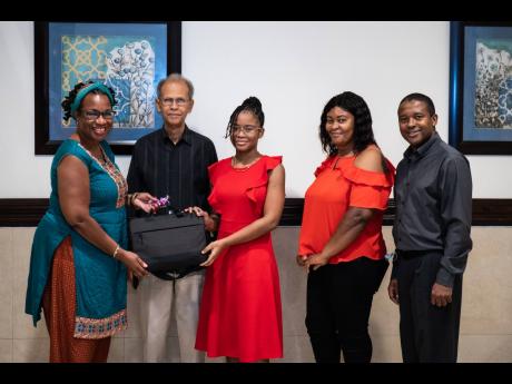 Credit: Contributed Haley Clarke (centre), who attends the Westwood High School for Girls in Trelawny, Jamaica, accepts her prize of a laptop computer after being chosen as one of five winners of the Food4Change Caribbean Story Writing Competition. Professor Alafia Samuels (l