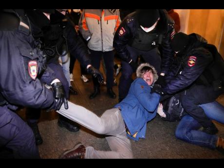 Police officers detain demonstrators in St Petersburg, Russia, yesterday. 