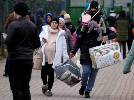 People fleeing the conflict from neighbouring Ukraine, arrive at the border crossing in Medyka, southeastern Poland. U.N. officials said that 100,000 people were believed to have left their homes and estimated up to four million could flee if the fighting 