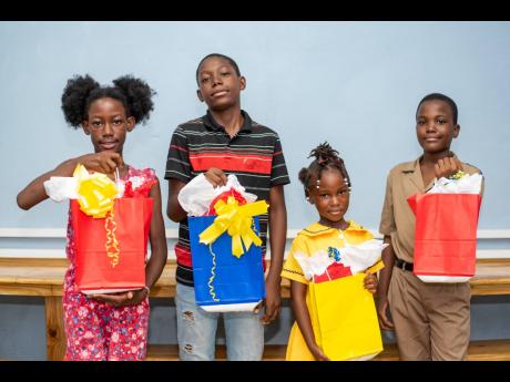 
From left: Dhalista Hibbert, Glenaldo Foster, Tishell Groves, and Nicholas Johnson of Tivoli Gardens with new tablets in hand donated by the students of the Creative Kids Learning Academy Junior Schools’ Challenge Quiz Team.