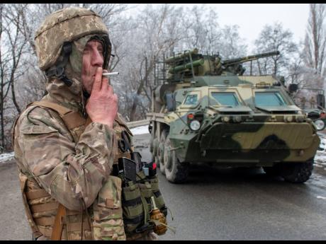 A Ukrainian soldier smokes a cigarette at his position at an armoured vehicle outside Kharkiv, Ukraine.