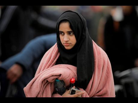 A student who fled the conflict from neighbouring Ukraine awaits transportation at the Romanian-Ukrainian border in Siret, Romania.