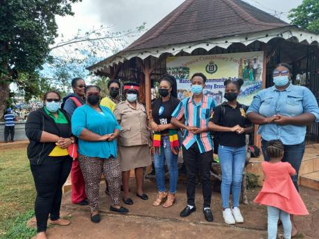Members of the Christiana Police Youth Club join sub-officer in charge of the Community Safety and Security Branch at the Mandeville Police Station, Inspector Berthlyn Lloyd (centre), at the domestic violence pop-up clinic organised last Friday at the Ceci