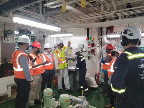 Lieutenant Commander Leighton Miller (fourth from left), MAJ marine surveyor, explains the process to the visitors during a Port State Control Inspection at Port Bustamante.