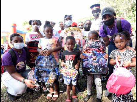 Siblings Timesha Warren (left) and Kimesha Warren (second right) pose with beneficiaries of their Twins Make a Wish Foundation annual back-to-school treat on Ash Wednesday. The treat was held in Farm district, Westmoreland, and catered to kids in Farm and 