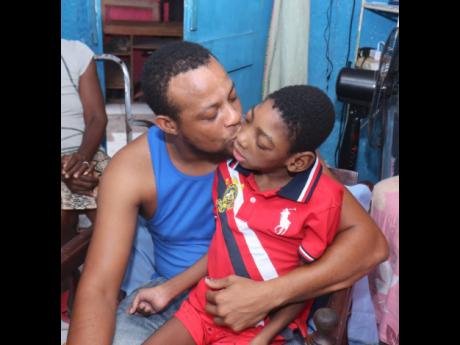 A loving single parent, Dennis Williams kisses his nine-year-old son Devonte who was diagnosed with cerebral palsy.