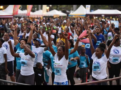Participants in the 2020 Sigma Run warm up with stretching before the start of the race on Sunday, February 16, 2020.