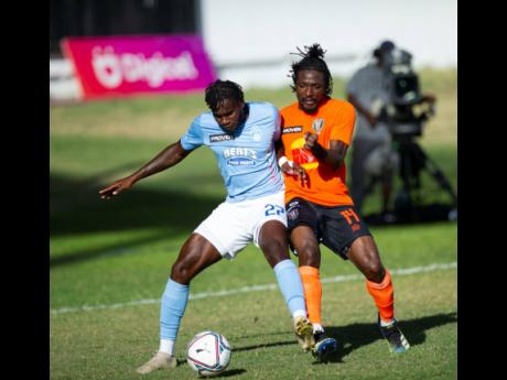 Waterhouse's Andre Leslie (left) duels with Tivoli Gardens' Kemar Flemmings during their Jamaica Premier League football match at Sabina Park earlier today.
