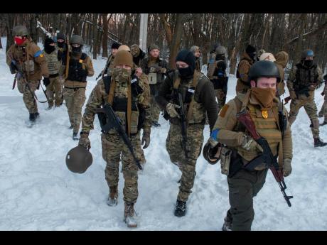 Ukrainian servicemen walk during a training session outside Kharkiv, Ukraine.