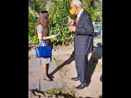 With his mask firmly in place and maintaining some distance between them, K.D. Knight chats with Rebecca Robertson, daughter of the late Dr Paul Robertson, after the official funeral at the University Chapel on Saturday.