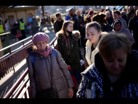 People wait in a line to board a train leaving for Lviv in Ukraine at the train station in Przemysl, Poland, on Monday. 
