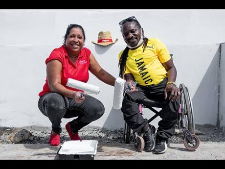 Paralympic gold medallist and Digicel brand ambassador Alphanso Cunningham (right), and Charmaine Daniels, chief executive officer, Digicel Foundation, during the volunteer activity on Jamaica’s first Paralympic Day.