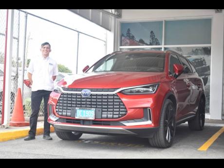James Lechler of Stewart’s Automotive Group stands next to a BYD electric vehicle being distributed by the company.