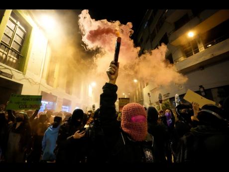 
A woman burns a flare during a march marking International Women’s Day in Quito, Ecuador, Tuesday, March 8.