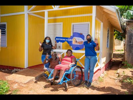 Clifton Vassell (second left) and Kadia Morrison (second right) accept the keys to their new home from BOOM Energy Drink’s Brand Manager Keteisha McHugh (left) and Food For The Poor’s  Development and Marketing Manager, Marsha Burrell-Rose. The couple,