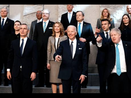 NATO Secretary General Jens Stoltenberg (centre, front left), US President Joe Biden (centre, front), and British Prime Minister Boris Johnson (front, right) pose for a group photo during an extraordinary NATO summit at NATO headquarters in Brussels, yeste