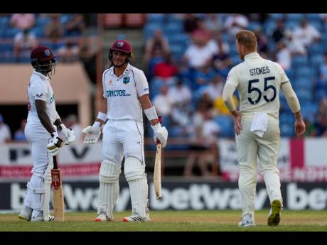 West Indies batsmen Joshua Da Silva (centre) and Kemar Roach look at England’s bowler Ben Stokes (right) during day two of the third Test match at the National Cricket Stadium in St George’s, Grenada, yesterday.