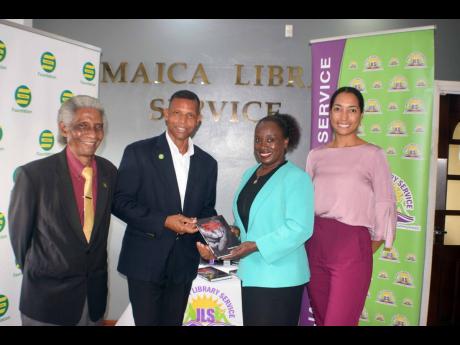 
Patrick Sterling, Group HR and industrial relations manager, Seprod Limited, presents Maureen Thompson, director general of the Jamaica Library Service, with 13 copies of Professor Neville Ying’s book, ‘Shaping a Servant Leader’. Looking on are auth