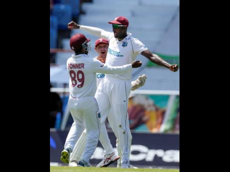 West Indies' Jason Holder celebrates taking the catch to dismiss England's Chris Woakes during day four of the third Test  match at the National Cricket Stadium in St. George, Grenada, Sunday, March 27, 2022. 