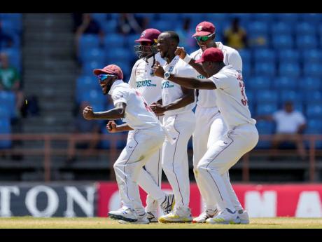West Indies' Kemar Roach (centre) celebrates with teammates the dismissal of England's Jack Leach during day four of the third Test cricket match at the National Cricket Stadium in St George's, Grenada, Sunday, March 27, 2022. 