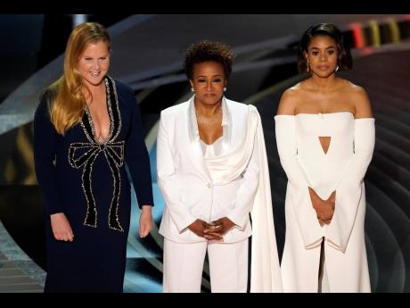 Hosts Amy Schumer (from left), Wanda Sykes, and Regina Hall appear on stage at the Oscars on Sunday. 