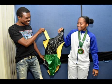 Credit: Kenyon Hemans/Photographer Gymnast Michala Virgo smiles alongside designer Michael Thomas. The gymnast won two individual medals at the Gasparilla Classics in Miami and is launching a leotard line.