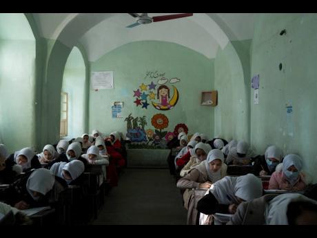 Afghan girls participate in a lesson inside a classroom at Tajrobawai Girls High School, in Herat, Afghanistan in November 2021. 