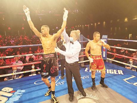 Credit: Contributed Referee Yvon Goulet (centre) raises the hand of Jamaican boxer Joshua Frazer (left) who defeated Luis Gonzalez by knockout at 1:57.00 minutes of round one in their fight scheduled for four rounds in Canada on Saturday night.