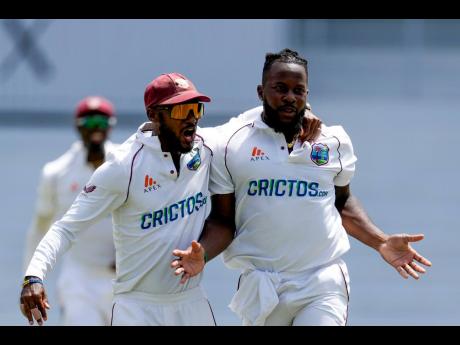 West Indies  captain Kraigg Brathwaite (left) embraces bowler Kyle Mayers after the dismissal of England’s Dan Lawrence during day three of their third Test cricket match at the National Cricket Stadium in St George’s,  Grenada on  Saturday, March 26, 