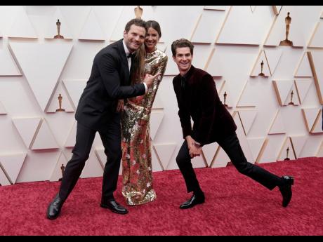 From left: Jamie Dornan, Amelia Warner and Andrew Garfield pose on the Oscars red carpet on Sunday. 