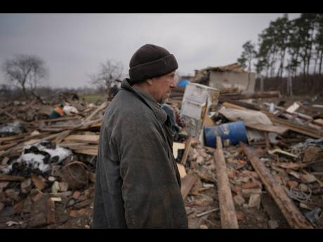 Credit: The Associated Press A man stands in the ruins of a house, destroyed during fighting between Russian and Ukrainian forces in the village of Yasnohorodka, on the outskirts of Kyiv, Ukraine, yesterday. Russian forces bombarded areas around Kyiv and another city, just hours after
