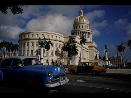A vintage Russian-made Lada car, right, and an American-made classic car drive past the Capitol in Havana, Cuba on Friday. Global restrictions on transport and trade with Russia after its invasion of Ukraine pose a serious problem for Cubans because much o