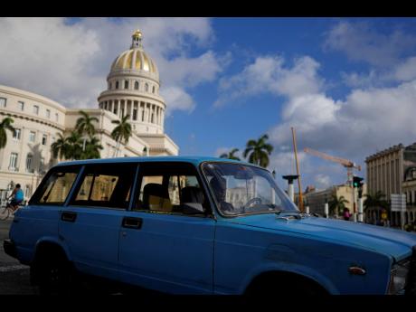 A driver navigates a vintage, Russian-made Lada station-wagon past the Capitol in Havana, Cuba on Friday. 