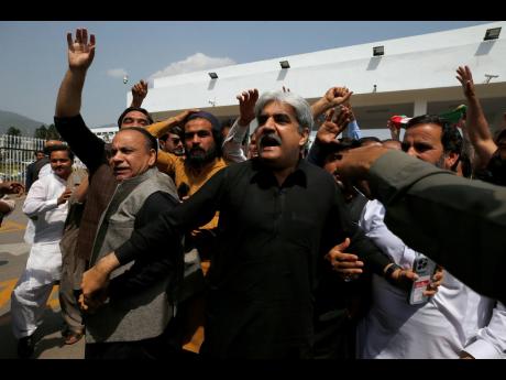 Lawmakers and supporters of the Pakistan Tehreek-e-Insaf party chant slogans in favour of their leader, Prime Minister Imran Khan, outside the National Assembly, in Islamabad, Pakistan, yesterday.