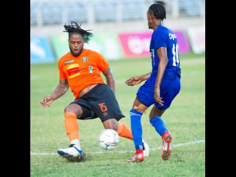 Tivoli Gardens’ Ranike Anderson (left) makes a strong tackle on Portmore United’s Shai Smith during yesterday’s Jamaica Premier League encounter at Sabina Park. The game ended in a 1-1 draw.