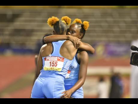 Edwin Allen twins Tina and Tia Clayton celebrate the former’s Class One 100-metre win at the ISSA/GraceKennedy Boys and Girls’ Athletics Championships inside the National Stadium yesterday.