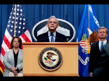 Attorney General Merrick Garland (centre), accompanied by Deputy Attorney General Lisa Monaco, and FBI Director Christopher Wray, speaks at a news conference at the Justice Department in Washington yesterday to discuss new and recent enforcement actions to
