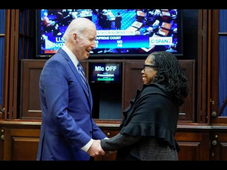 President Joe Biden holds hands with Supreme Court nominee Judge Ketanji Brown Jackson as they watch the Senate vote on her confirmation from the Roosevelt Room of the White House in Washington yesterday.