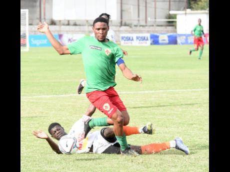 Odane Murray (right) of  Humble Lion evades a tackle from Fabian Pascoe  of Tivoli Gardens  during their  Jamaica Premier League football match at the Anthony Spaulding Sports Complex yesterday. The game ended in a 1-1 draw.