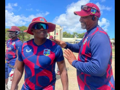 West Indies head coach Phil Simmons chats with batsman Devon Thomas during a training session in Antigua and Barbuda.
