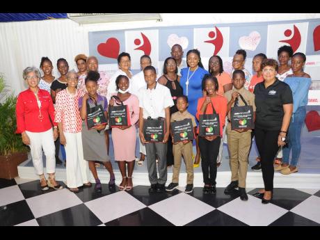 Kim Mair (left, front row), CEO, JMMB Joan Duncan Foundation; Beverly Manley Duncan (second left, front row) and Patricia Sutherland (right, front row), chairman of the foundation, share a photo op with six of the Beverly Manley Duncan scholars who were re
