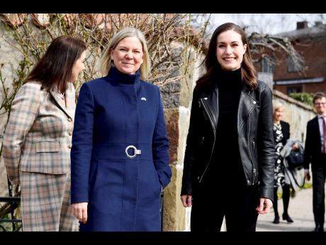 Swedish Prime Minister Magdalena Andersson (left) and Finnish Prime Minister Sanna Marin pose for photographers ahead of a meeting on whether to seek NATO membership, in Stockholm, Sweden, yesterday.